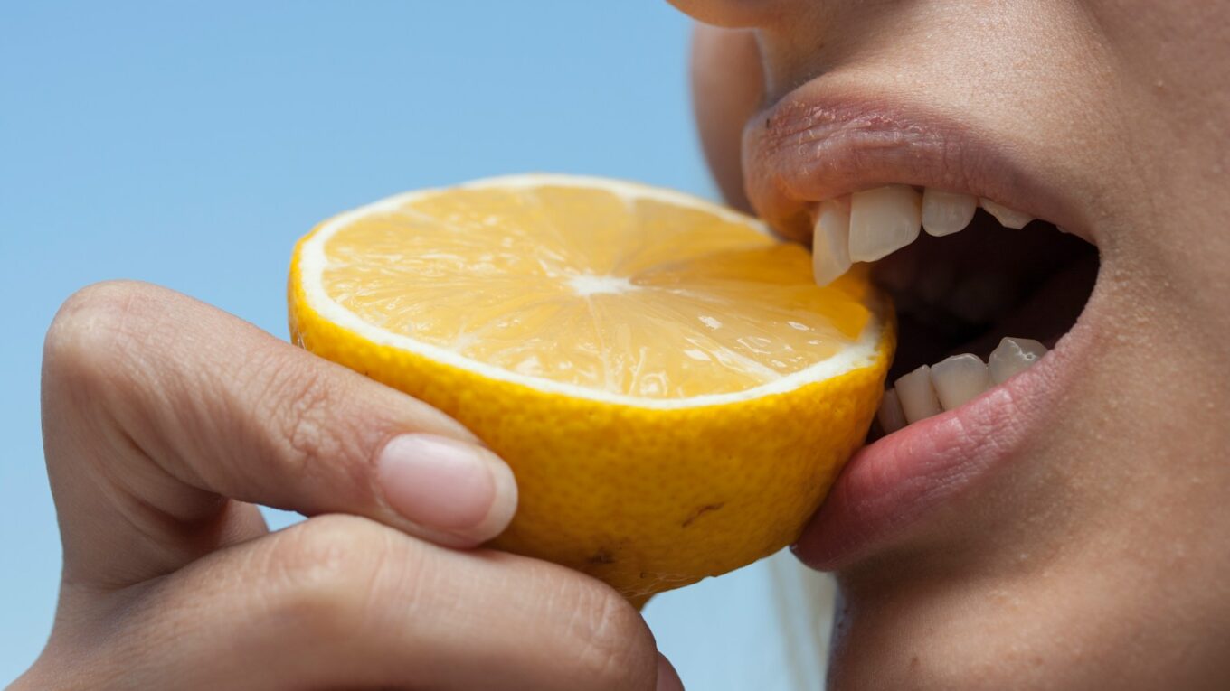 person holding orange fruit during daytime