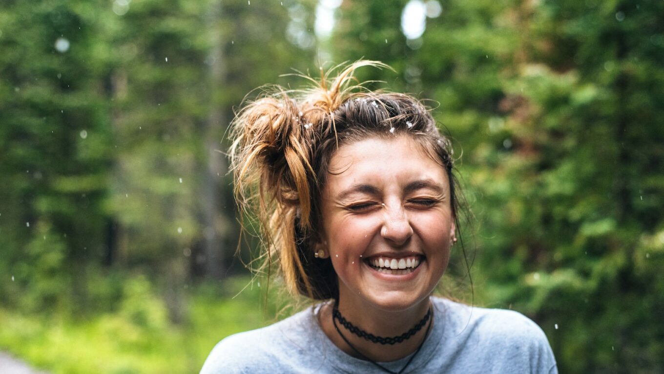 woman smiling near tree outdoor during daytime